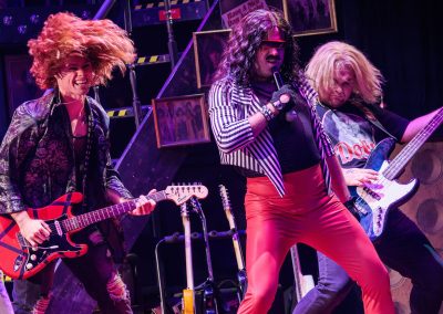 Beau Harmon (center) as Joey Primo and Brevan Collins and Evan Sleppy as Arsenal in The REV Theatre Company’s production of ROCK OF AGES.